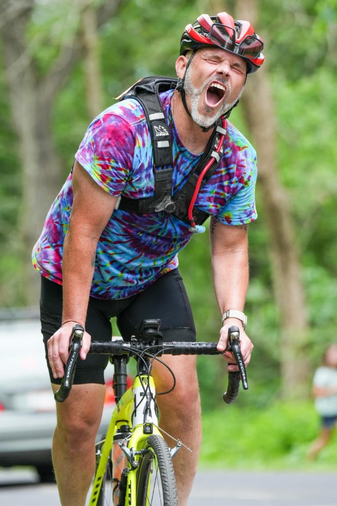 A bike rider expresses the pain of the hilly section of the L'Alpe Bl'Huez Hill Climb