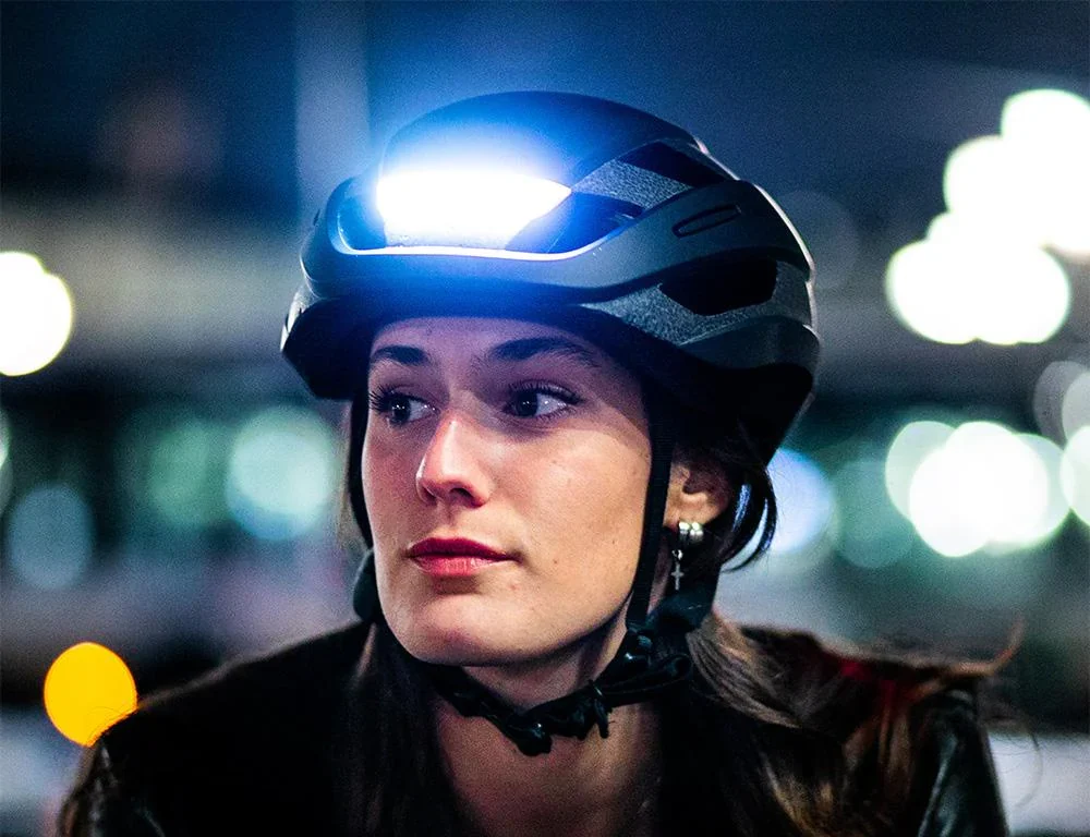 A close-up of a woman seen riding her bike with a Lumos smart helmet.